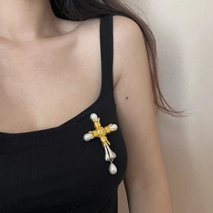 Detailed close-up of Baroque vintage cross brooch with pearls worn on model