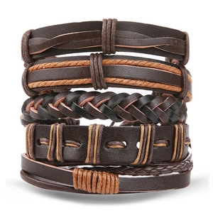 Detail of stacked handmade leather woven bracelets in dark brown and tan punk style
