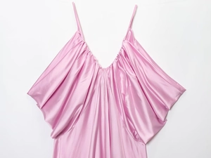 Detailed view of the pink satin dress featuring a V-neckline and pleated chest texture