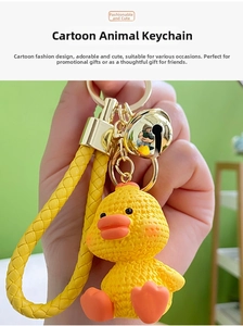 Detail of yellow cartoon duck keychain with woven strap and golden bell accessory
