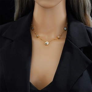 Elegante collana in acciaio al titanio dorato con ciondoli a farfalla bianchi e neri