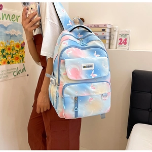 Detail of gradient pink-blue school backpack featuring butterfly moon prints and buckle straps