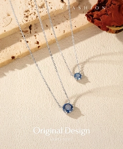 Close-up of S925 silver necklace featuring a sparkling blue round faceted gemstone pendant