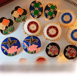 Close-up of vintage enamel floral and bird patterns with gold plating detail on earrings