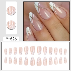 Almond fake nails in nude pink with elegant white swirls and gold glitter accents