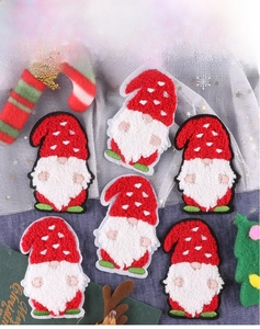 Detail of six Christmas gnome patches with textured towel embroidery on denim background
