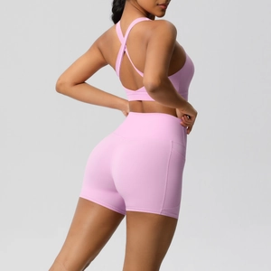 Detail of pink yoga set showing back cross straps and high waist shorts with pockets