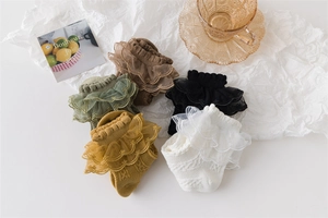 Flat lay of five lace-trimmed cotton socks in assorted colors with floral accents