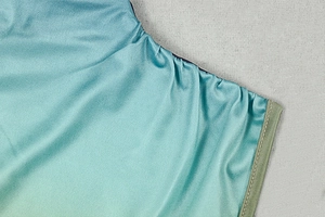 Detailed view of shimmery gradient turquoise knit fabric with reinforced shoulder stitching