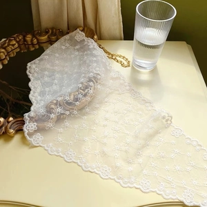 Detailed view of floral lace embroidery and scalloped edges on white triangle bandana