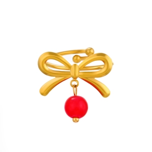 Close-up of golden bow ring with red round bead pendant and adjustable open band