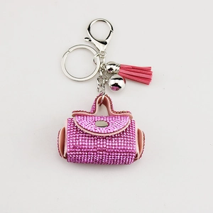 Pink rhinestone handbag keychain with fringe tassel and silver lobster clasp on white background