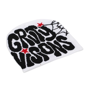 Detail of white beanie showing jacquard letters stars and spider web knit patterns