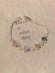 Detailed close-up of sparkling colorful zircon oval gemstones on a silver chain bracelet