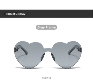 Detail of frameless heart-shaped sunglasses with grey lenses and slim metal temples