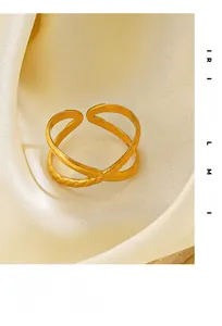 Detail of 18K gold-plated X-shape cross ring with textured rope design on satin fabric
