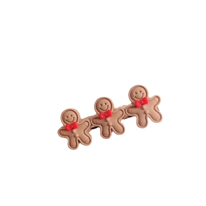 Cute gingerbread man hair clip with three brown cartoon figures and red bow ties