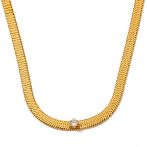Detail of gold flat snake bone chain necklace featuring a single round zircon centerpiece