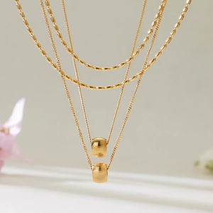 Collier double couche en or avec pendentifs cylindriques rainurés et chaîne à billes