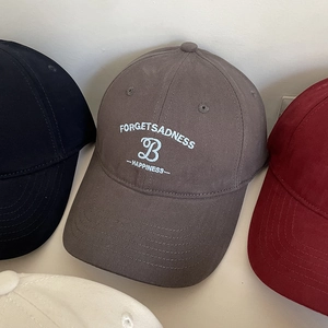 Détail de la broderie lettre B sur des casquettes en coton de plusieurs couleurs variées