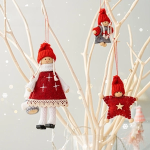 Handmade Christmas tree ornaments featuring red knitted dolls on white wooden branches