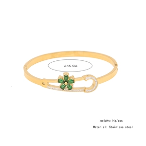 Detail of gold stainless steel safety pin bangle with green zircon flower and tiny crystals