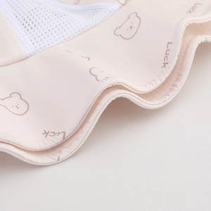 Close-up of breathable mesh fabric with bear patterns and Luck text on a sun hat