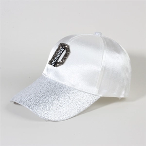 Macro detail of white baseball cap with silver sequins and sparkling rhinestone D patch