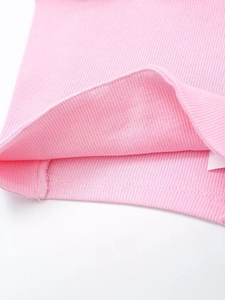 Detail view of pink ribbed knit fabric texture and high-quality stitching on the garment