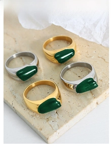 Macro shot of French vintage emerald rings in gold and silver on stone texture