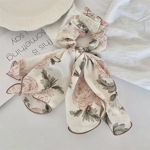 Chouchou à motif floral avec rubans sur tissu crème pour un style élégant et vintage