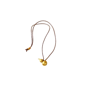 Brushed gold gourd pendant necklace with brown rope cord on a minimalist white background