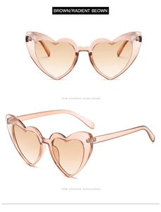 Detail view of heart-shaped brown sunglasses with gradient lenses and metal hinges