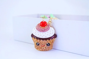 Detail of crystal rhinestone cupcake keychain with enamel finish and gold lobster clasp