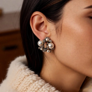Primo piano di orecchini vintage a fiore con perle e strass su una modella