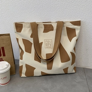Canvas tote bag with cute cartoon rabbit print and Good Student text in a casual setting
