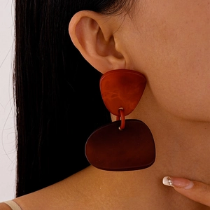 Vue macro de profil d'un mannequin portant des boucles d'oreilles en résine