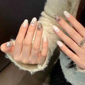 Short press-on nails with handmade bow, pearls and heart patterns on beige base