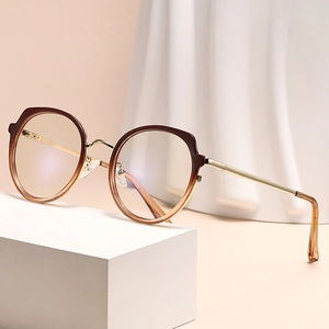 Monture de lunettes ronde dégradé marron avec branches en métal doré sur socle blanc épuré