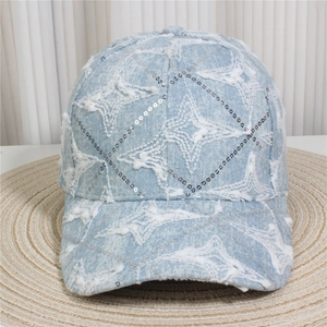Detailed macro view of denim baseball cap featuring sparkly sequins and white star patch