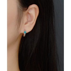 Detailed close-up of s925 silver hoop earring with blue turquoise on woman's ear