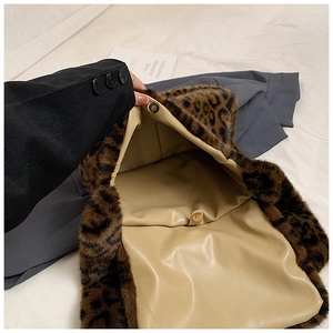 Detalle del bolso de felpa con estampado de leopardo y cierre magnético de metal