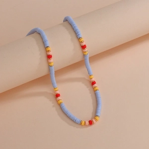 Detail of bohemian colorful beaded necklace with blue, yellow, red and gold flat discs