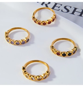 Primo piano di anelli placcati oro 18K con incastonati zirconi rotondi colorati