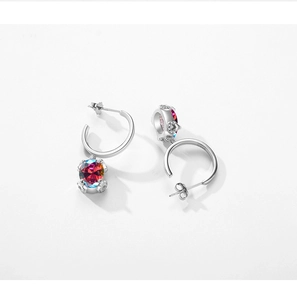 Macro shot of silver earrings with sparkling round colored gems and micro-pave accents