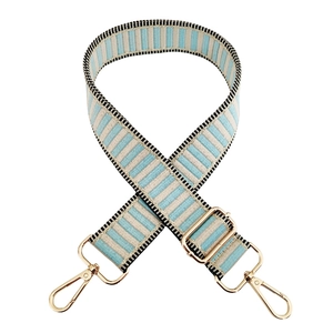 Detail of blue and beige striped bag strap with gold metal hooks and adjustable buckle