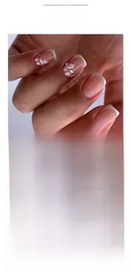 Detailed view of short square French pink press-on nails with white floral and silver accents