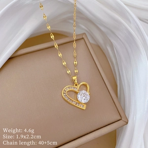 Close-up of gold titanium heart pendant with zircon inlay on a soft silk background