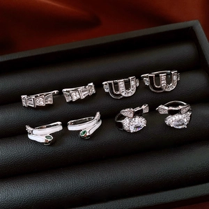 Silver snake-shaped ear clips set with cubic zirconia displayed in a jewelry box