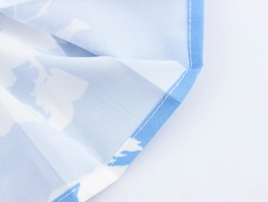 Makroaufnahme von blauem Blumenstoff mit plissierter Textur und feiner blauer Versäuberung